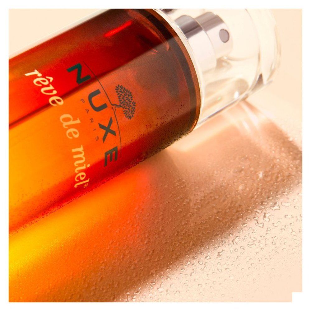 Nuxe Rêve de Miel Eau Savoureuse Parfumante fles met spraykop. Bruin en geel kleurverloop design.