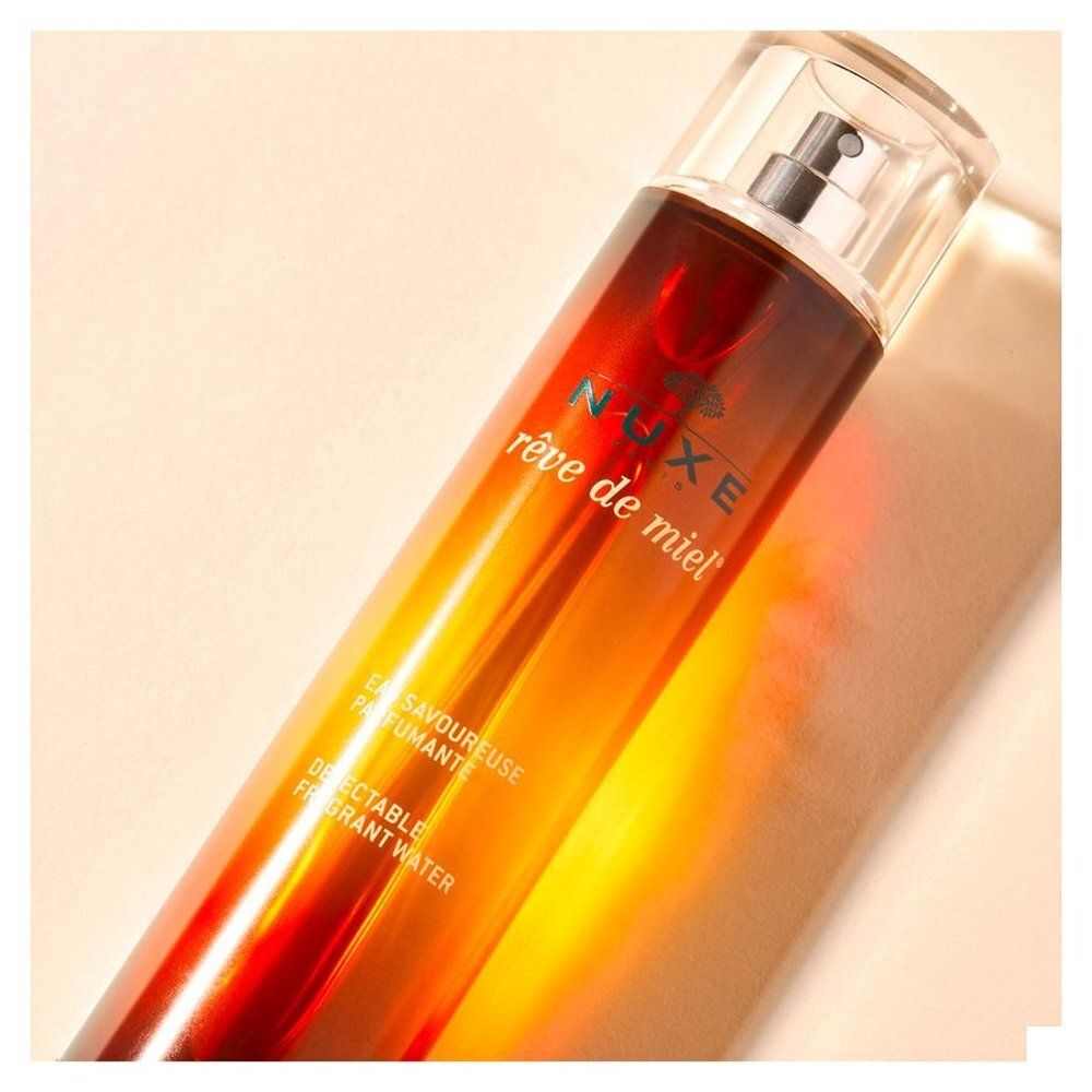 Flacon Nuxe Rêve de Miel Eau Savoureuse Parfumante avec vaporisateur. Design dégradé brun et jaune.