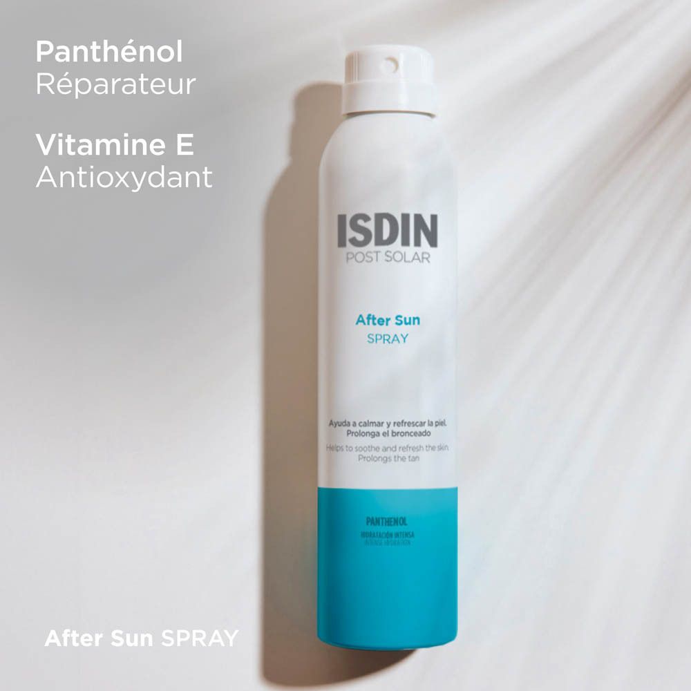 Personne vaporisant avec un flacon spray blanc et bleu. Inscription: ISDIN POST SOLAR After Sun SPRAY. Application sur la peau.
