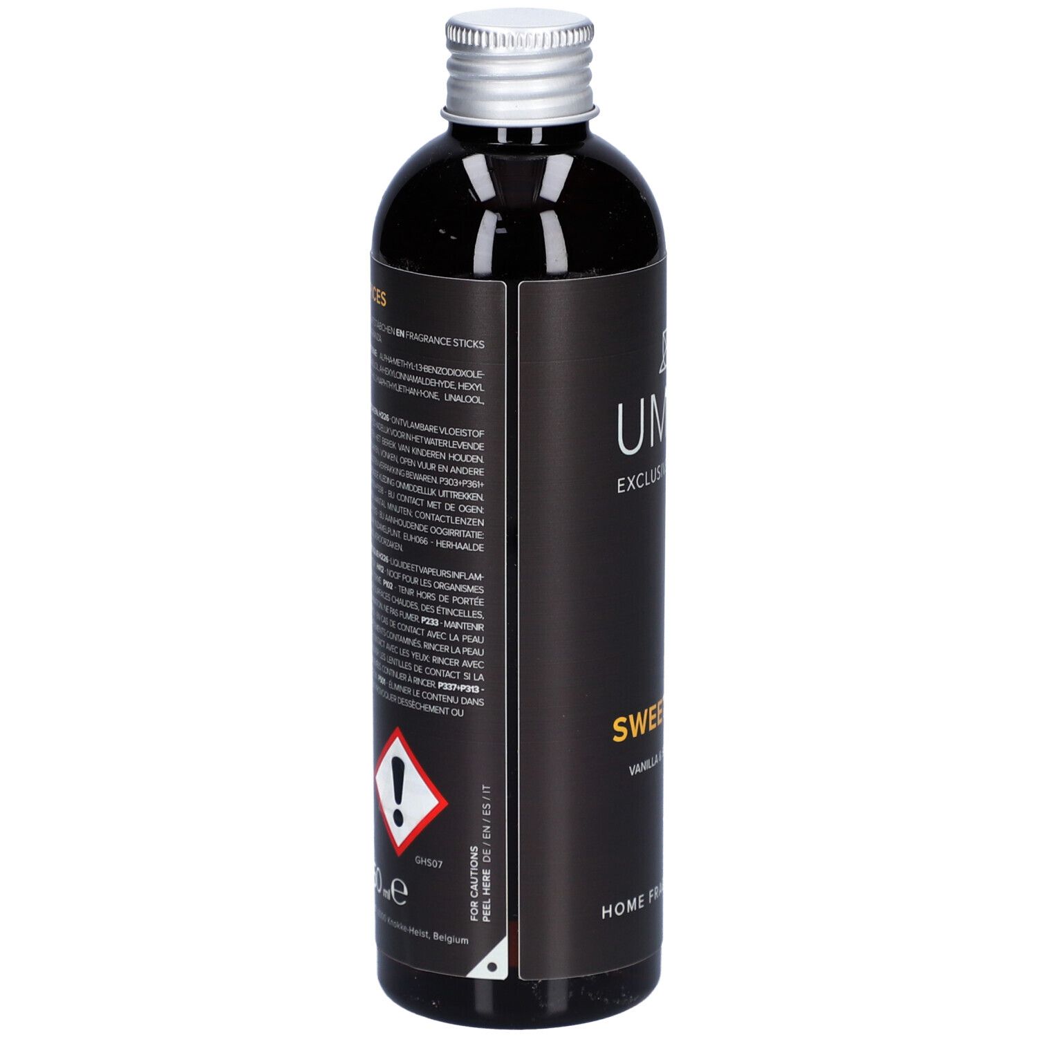 Donkere fles met zilveren dop. Etiket met tekst en gevaarsymbolen. Opschrift: Sweet Spices, Home Fragrance Refill.