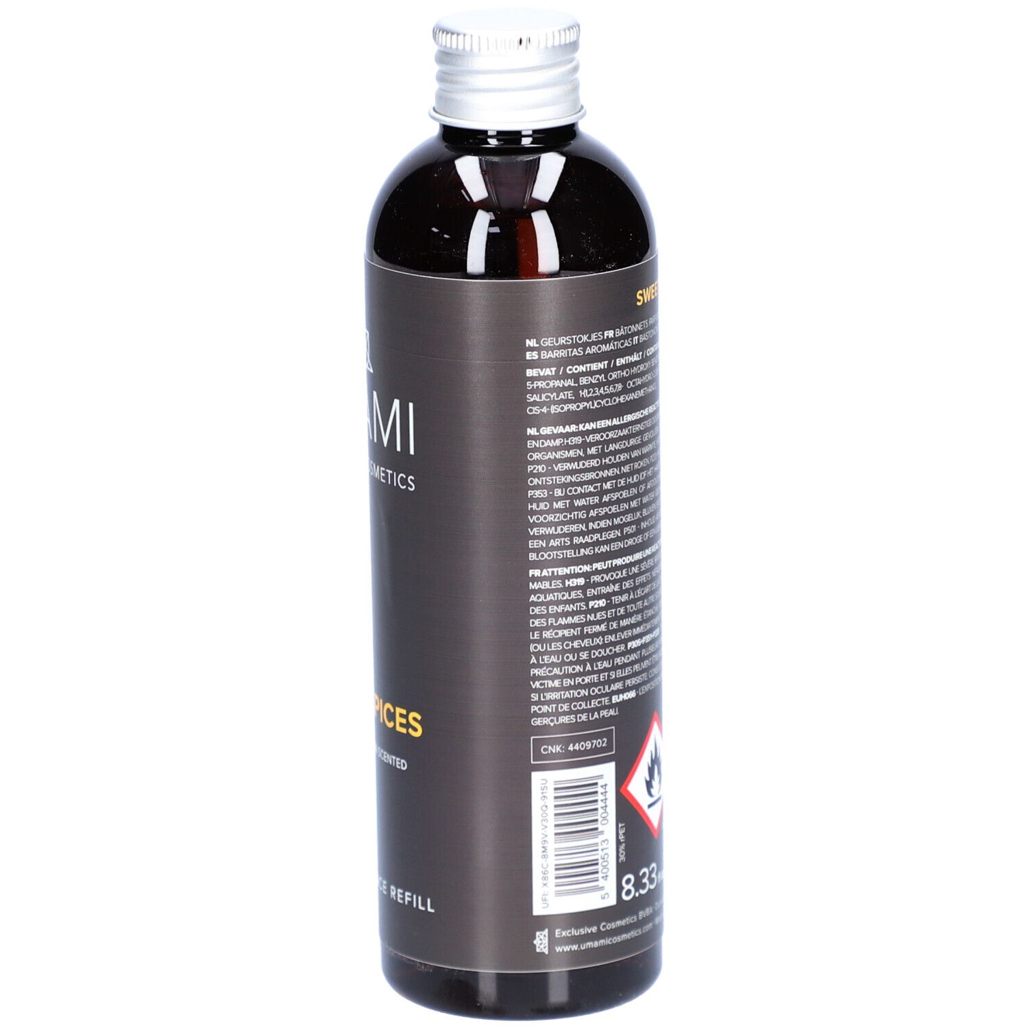 Donkere fles met zilveren dop. Etiket met tekst en gevaarsymbolen. Opschrift: Sweet Spices, Home Fragrance Refill.