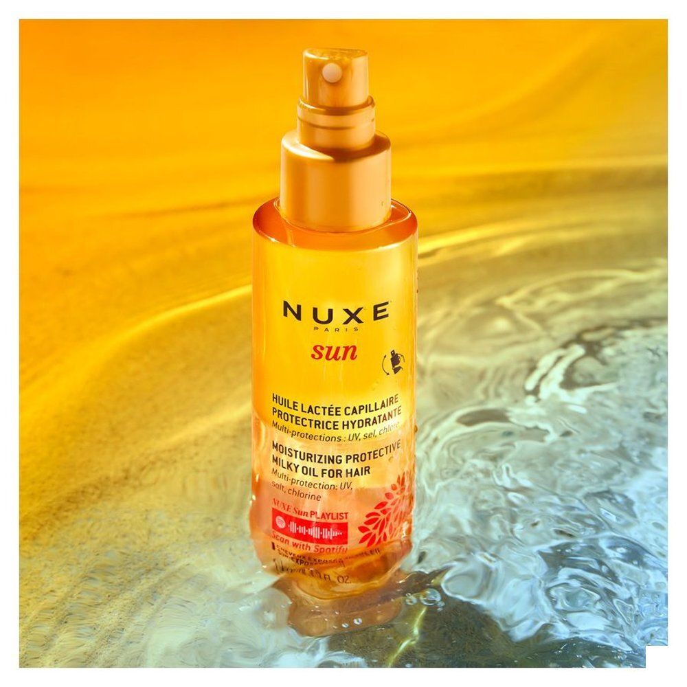 Huile Nuxe Sun pour cheveux en flacon transparent avec spray doré et étiquette.