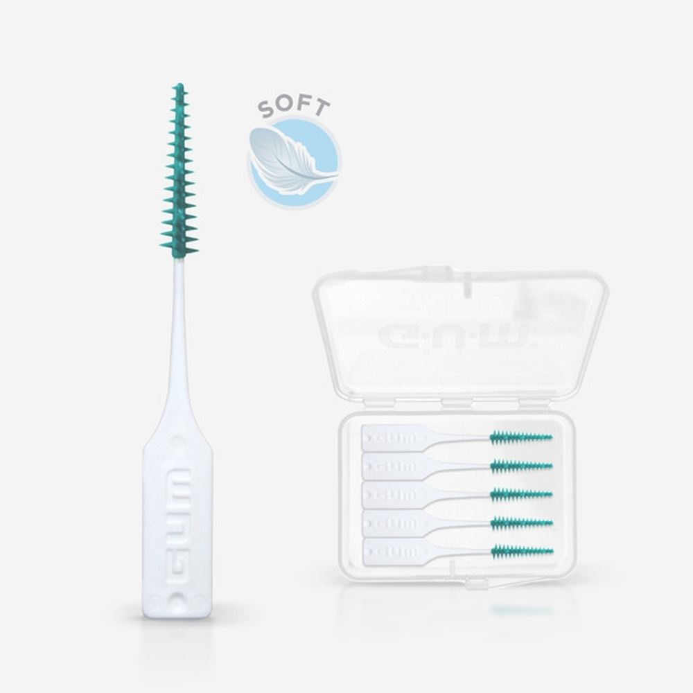 Enkele GUM Soft-Picks. Witte handgreep, groene borstelkop. Naast een open, lege doos met Soft-Picks.