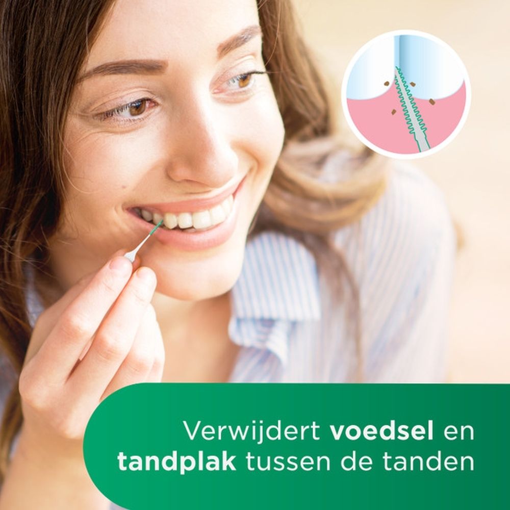 Vrouw gebruikt GUM Soft-Picks. Close-up van de mond. De pick reinigt de tanden. Tekst: Verwijdert voedsel.