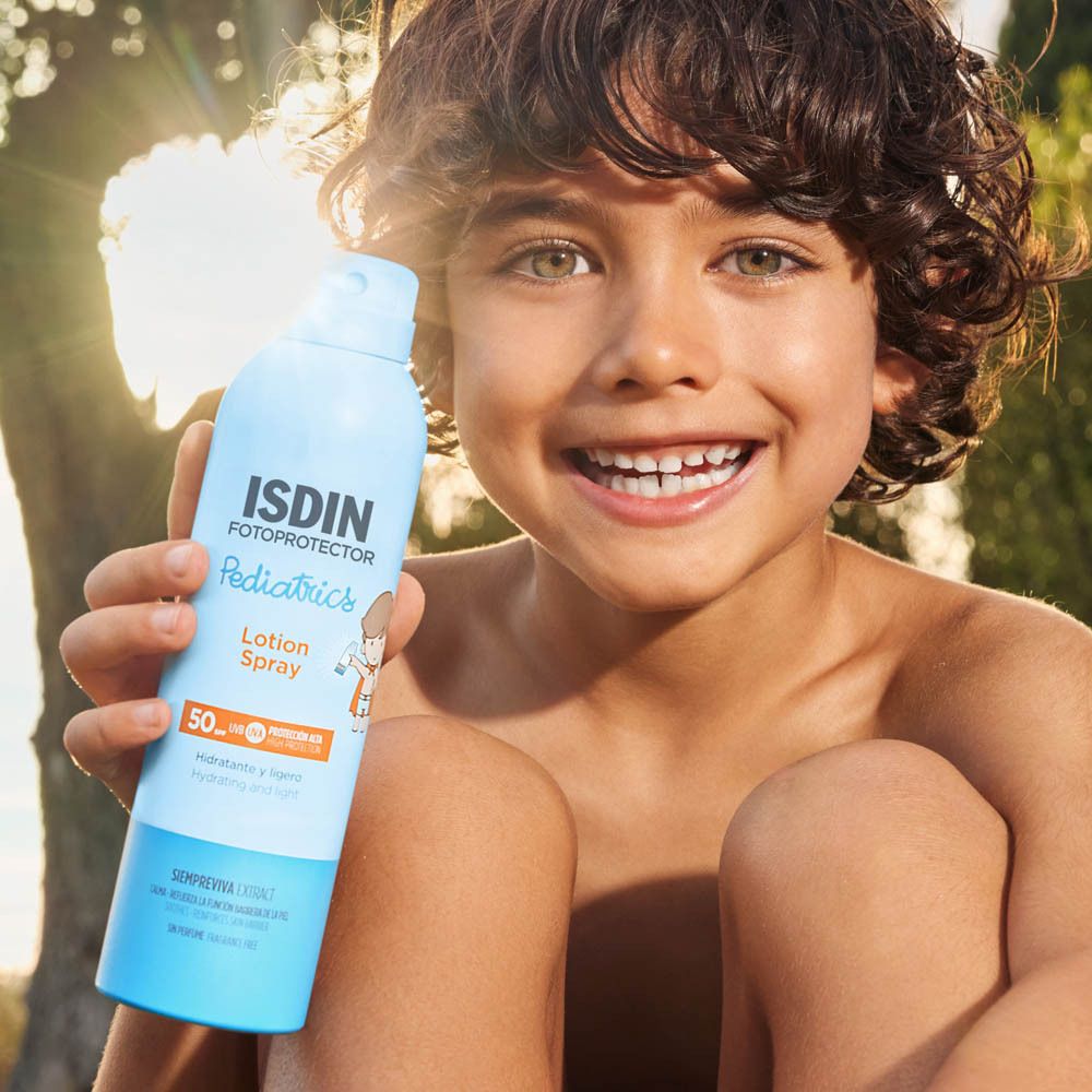 Kind houdt ISDIN Fotoprotector Pediatrics Lotion Spray vast. Product buiten.
