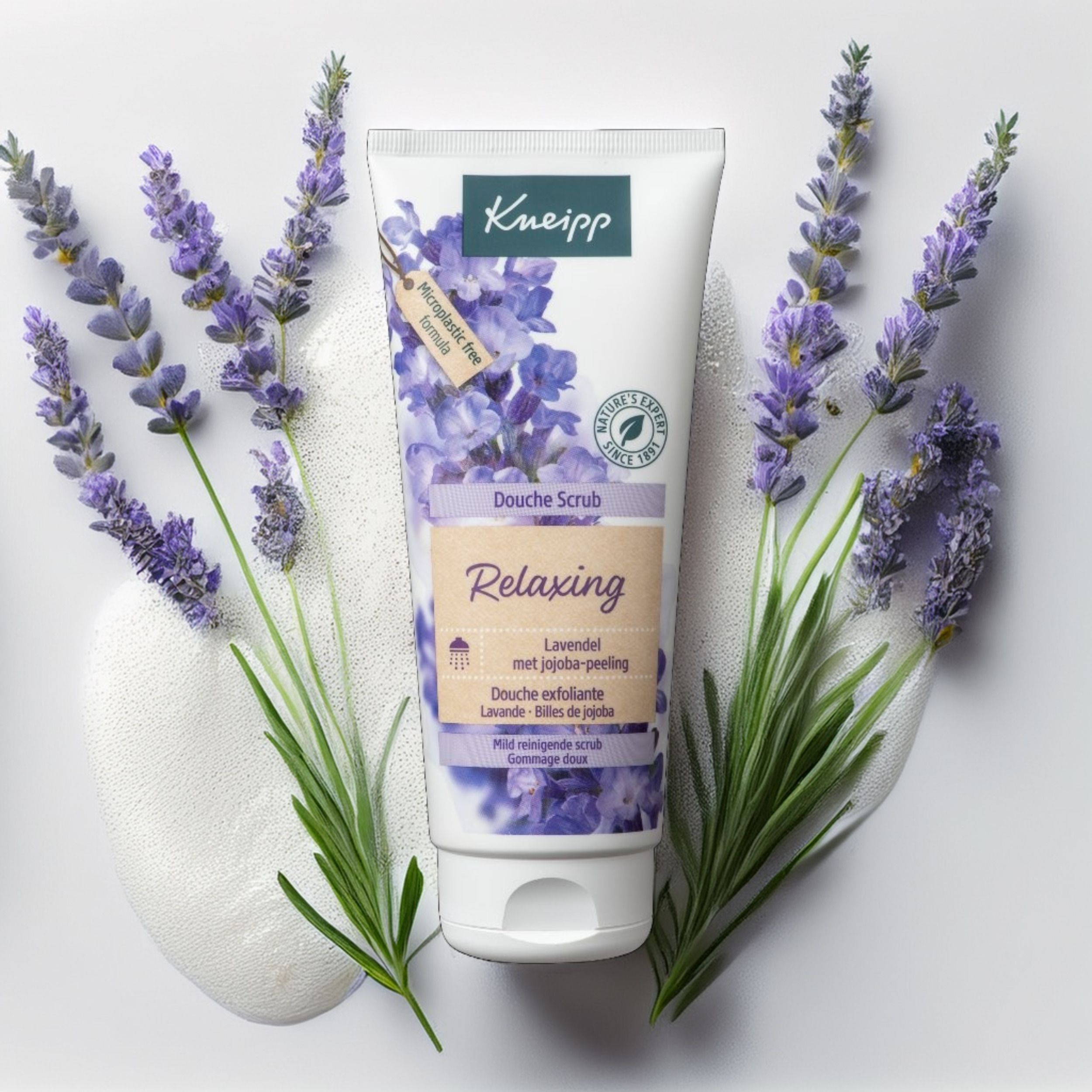 Witte tube met Kneipp-logo en lavendel-illustratie, omringd door lavendelbloemen. Tekst: Douche Scrub Relaxing.
