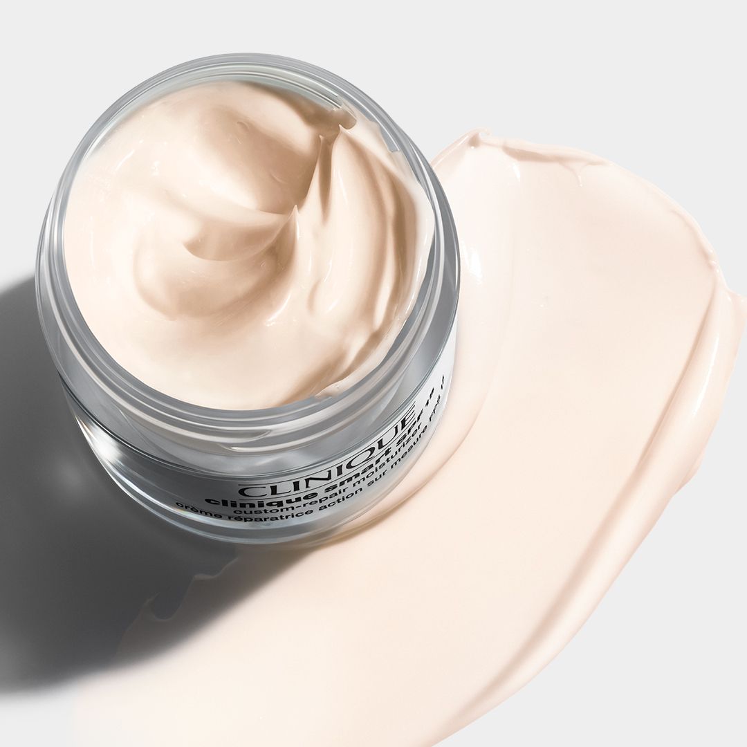 Glazen pot met crème en romige textuur. Op een licht oppervlak. Tekst: CLINIQUE.