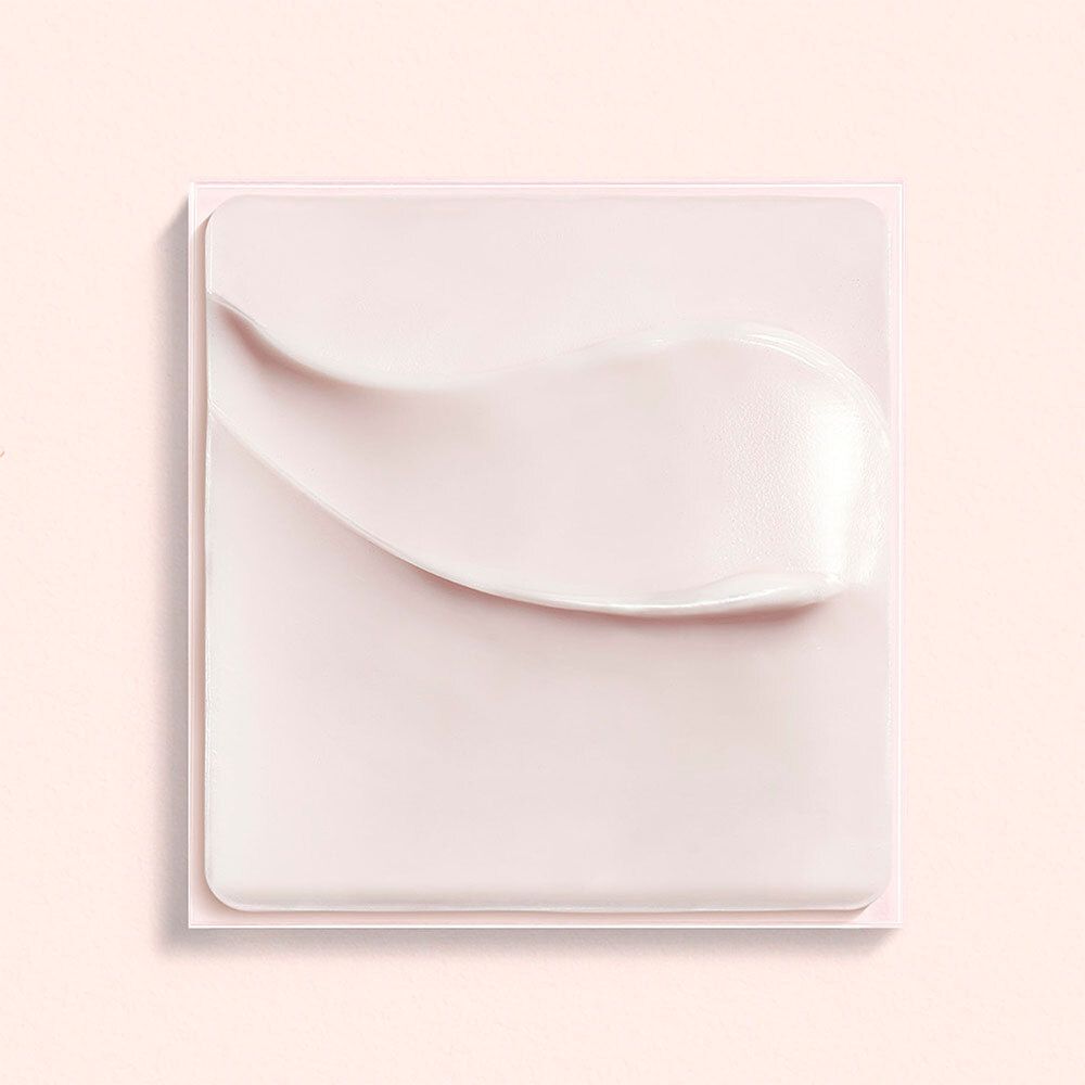 Roze crème op vierkante ondergrond. Crèmetextuur zichtbaar.
