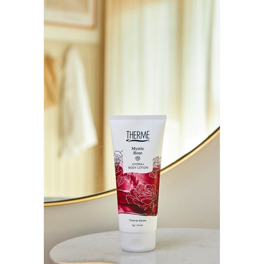 THERME Mystic Rose Hydra+ bodylotion tube op een marmeren tafel voor een spiegel.