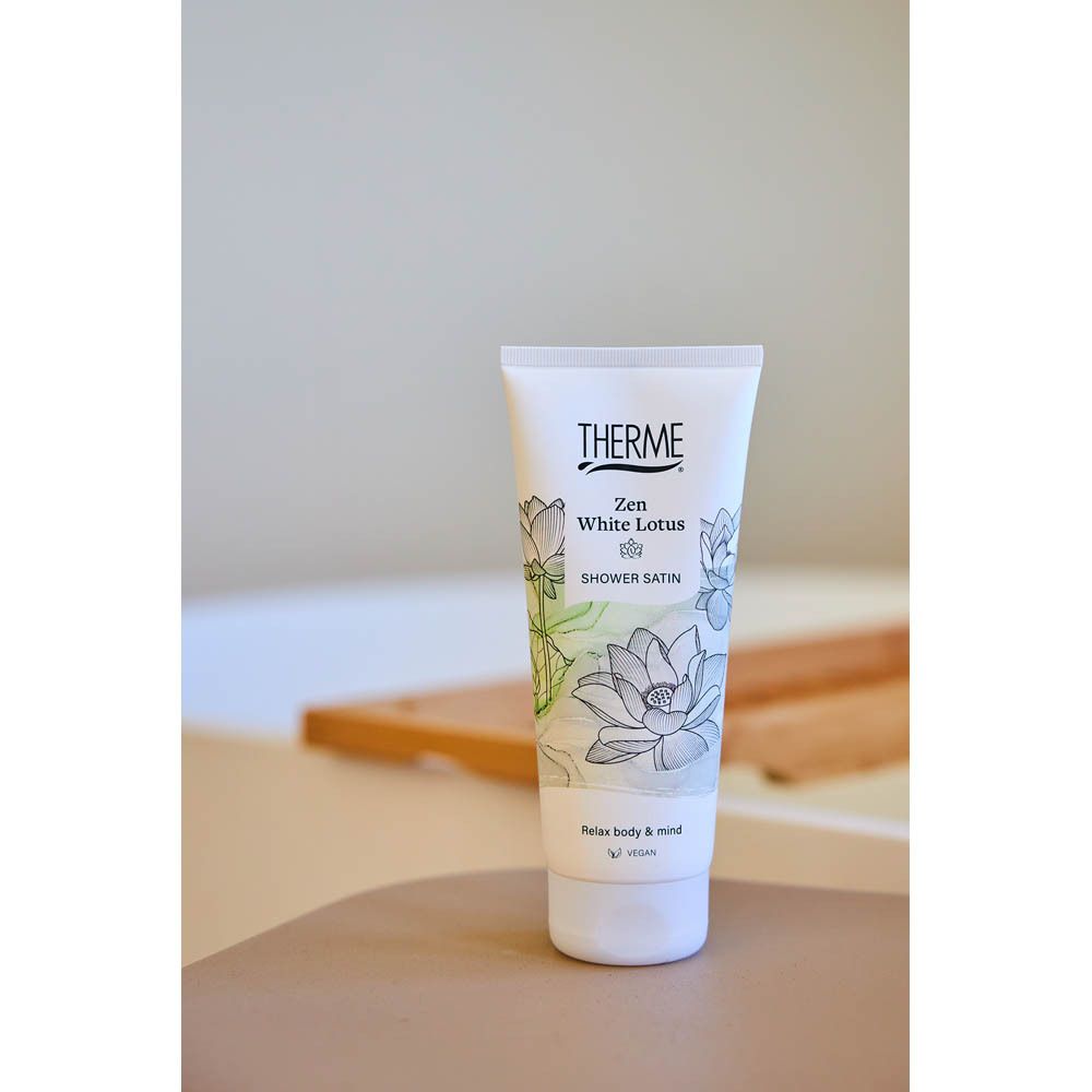 Product in badkameromgeving. Witte tube met THERME-logo en Zen White Lotus-design.