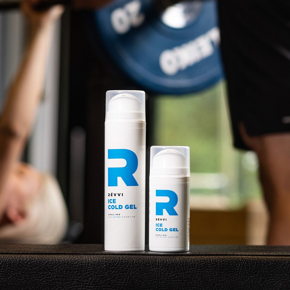 Twee witte flessen met blauw "R"-logo en tekst: RÉVVI ICE COLD GEL. Kleine en grote fles.