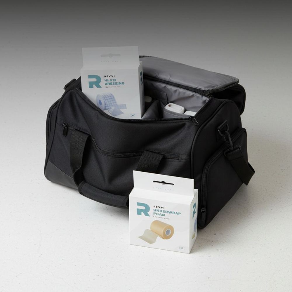 Deux boîtes de RÉVVI Underwrap Foam et d'autres articles dans un sac de sport noir. Étiquettes de produit visibles.