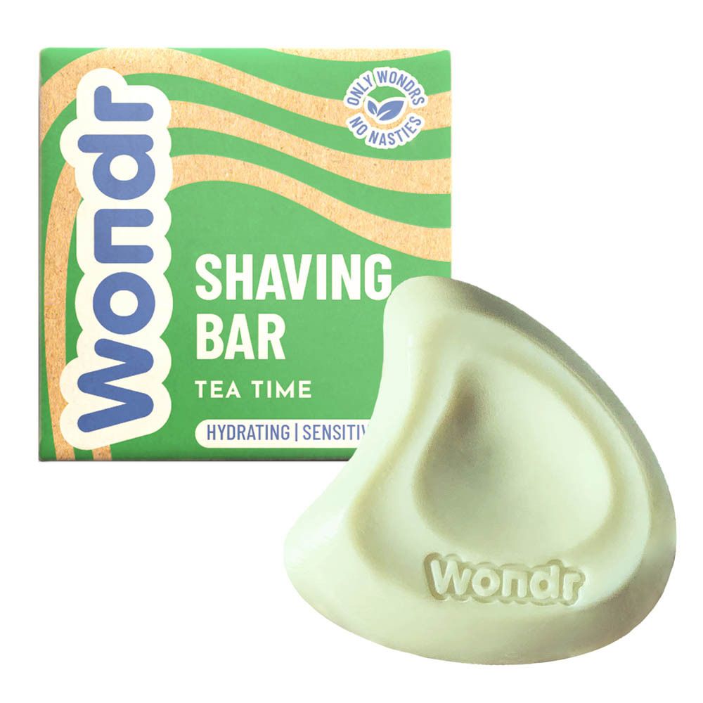 Groene scheerzeep naast kartonnen verpakking. Zeep met Wondr-logo. Verpakking met "Shaving Bar Tea Time".
