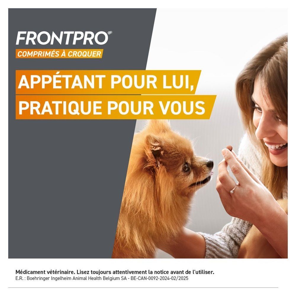 Chien mangeant une friandise FRONTPRO dans une main.