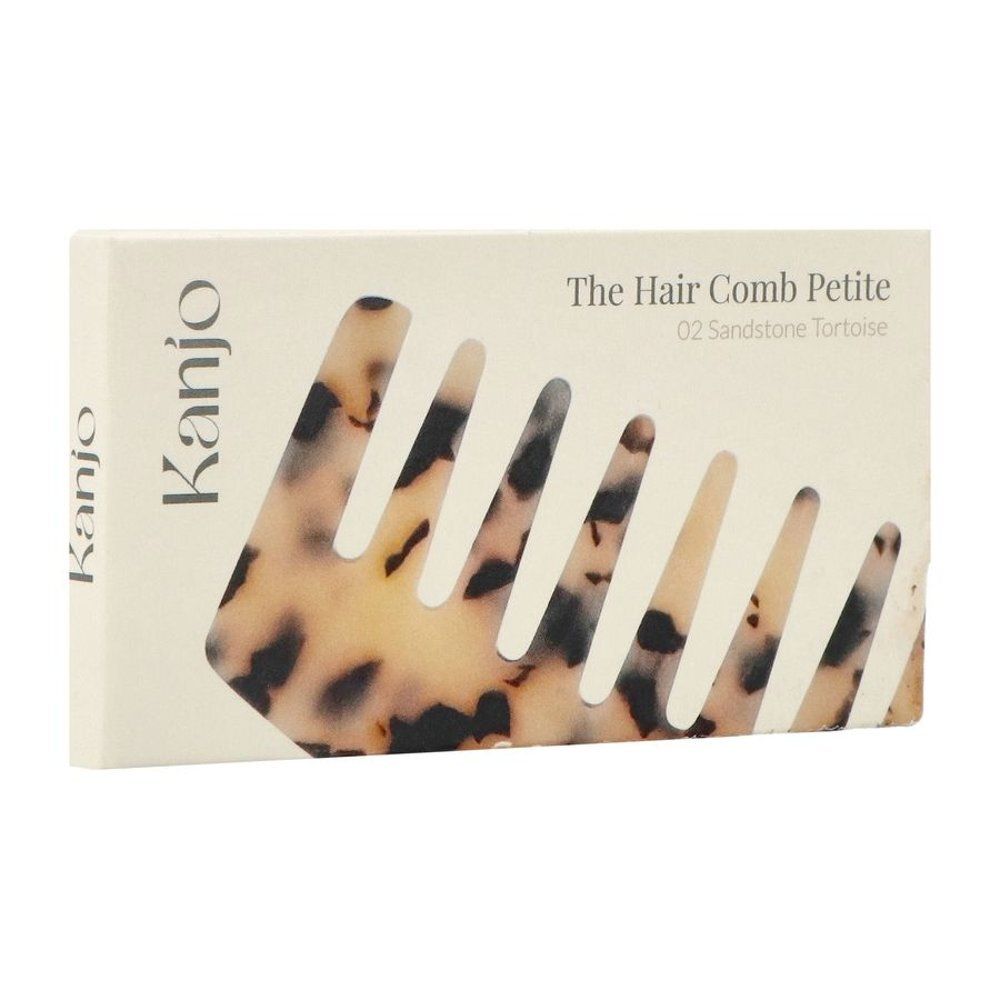 Emballage en carton avec image du produit. Inscription : Kanjo, The Hair Comb Petite 02 Sandstone Tortoise.