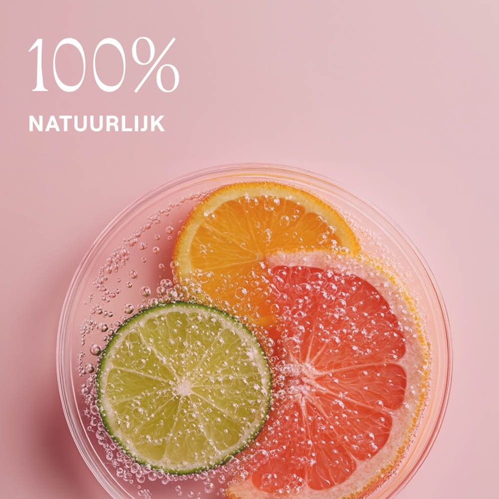 Citrusvruchten in een glazen schaal op roze achtergrond. Tekst: 100% natuurlijk.