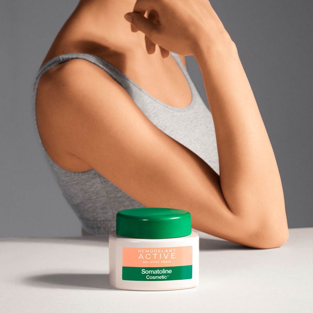 Bras d'une personne avec pot à couvercle vert. Étiquette avec texte: REMODELANT ACTIVE GEL EFFET FRAIS, Somatoline Cosmetic.