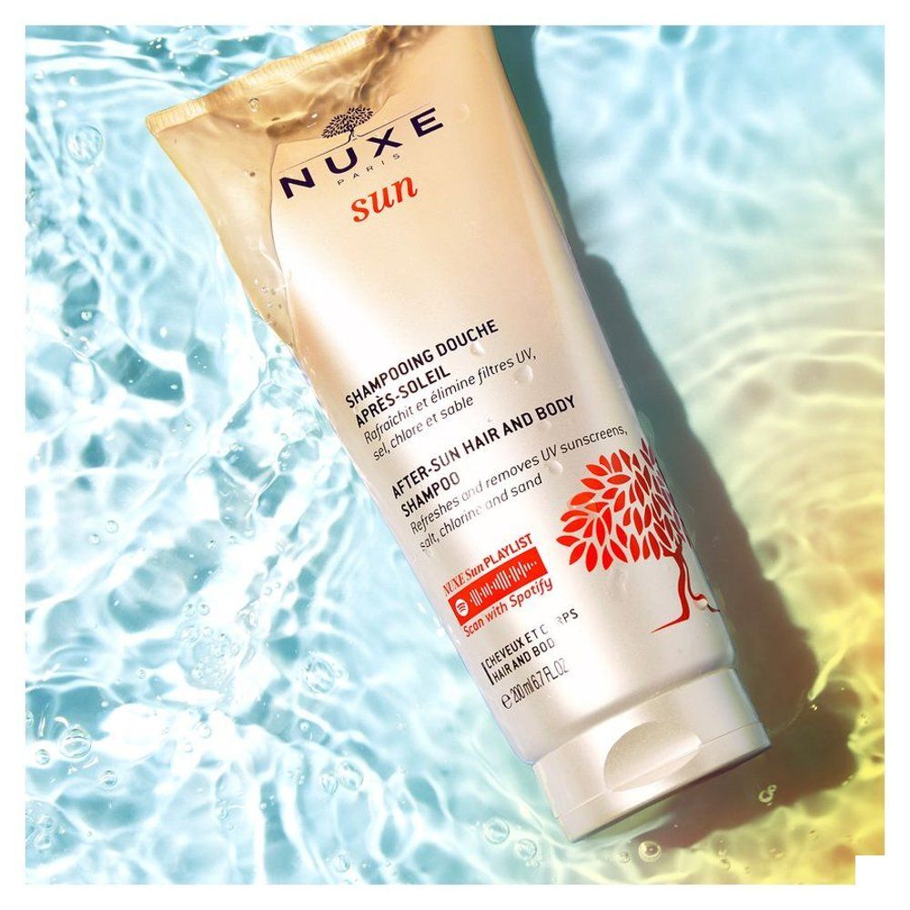 Nuxe After-Sun Shampoo fles in water met bubbels.