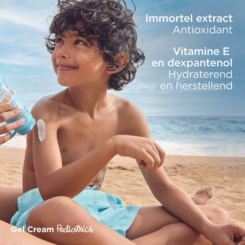 Kind op het strand. ISDIN Fotoprotector Pediatrics Gel-Crème SPF50+ wordt aangebracht.