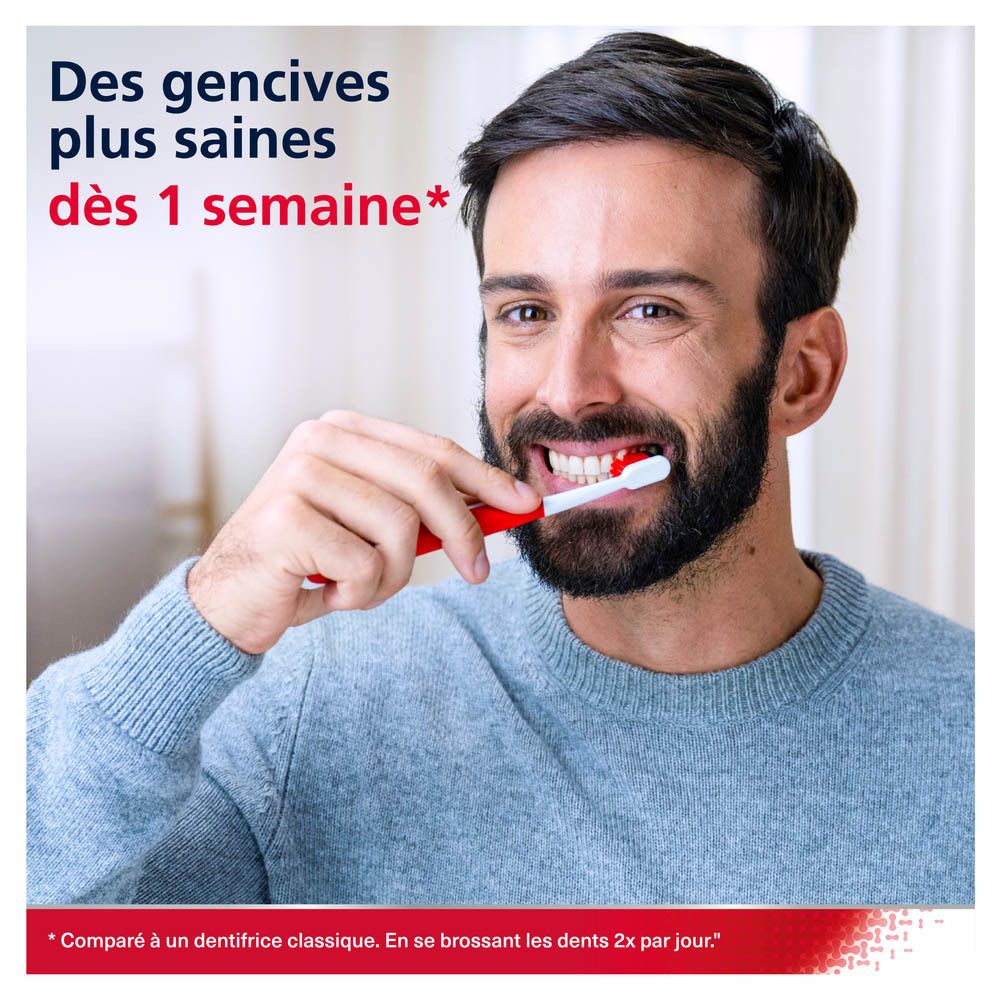 Femme souriante, se brossant les dents. Brosse à dents dans la bouche.