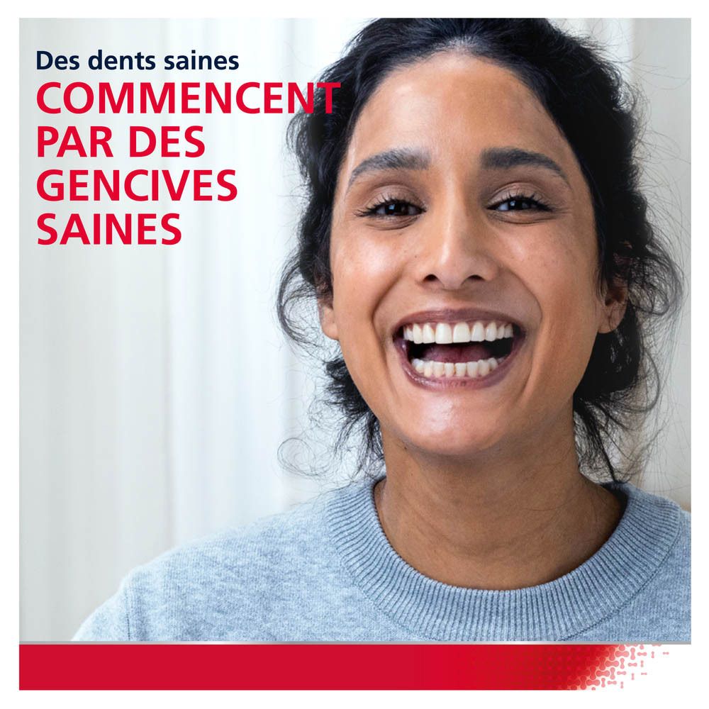 Femme souriante, se brossant les dents. Lunettes, brosse à dents dans la bouche.