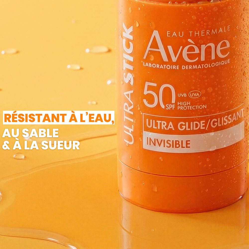 Gros plan d'un stick solaire orange. Texte: Résistant à l'eau, au sable et à la sueur.