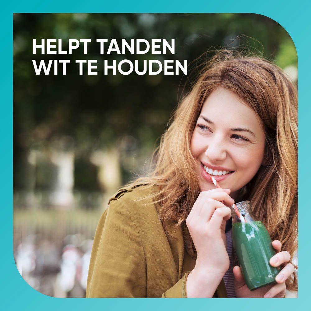 Helpt tanden wit te houden. Vrouw drinkt groene smoothie.