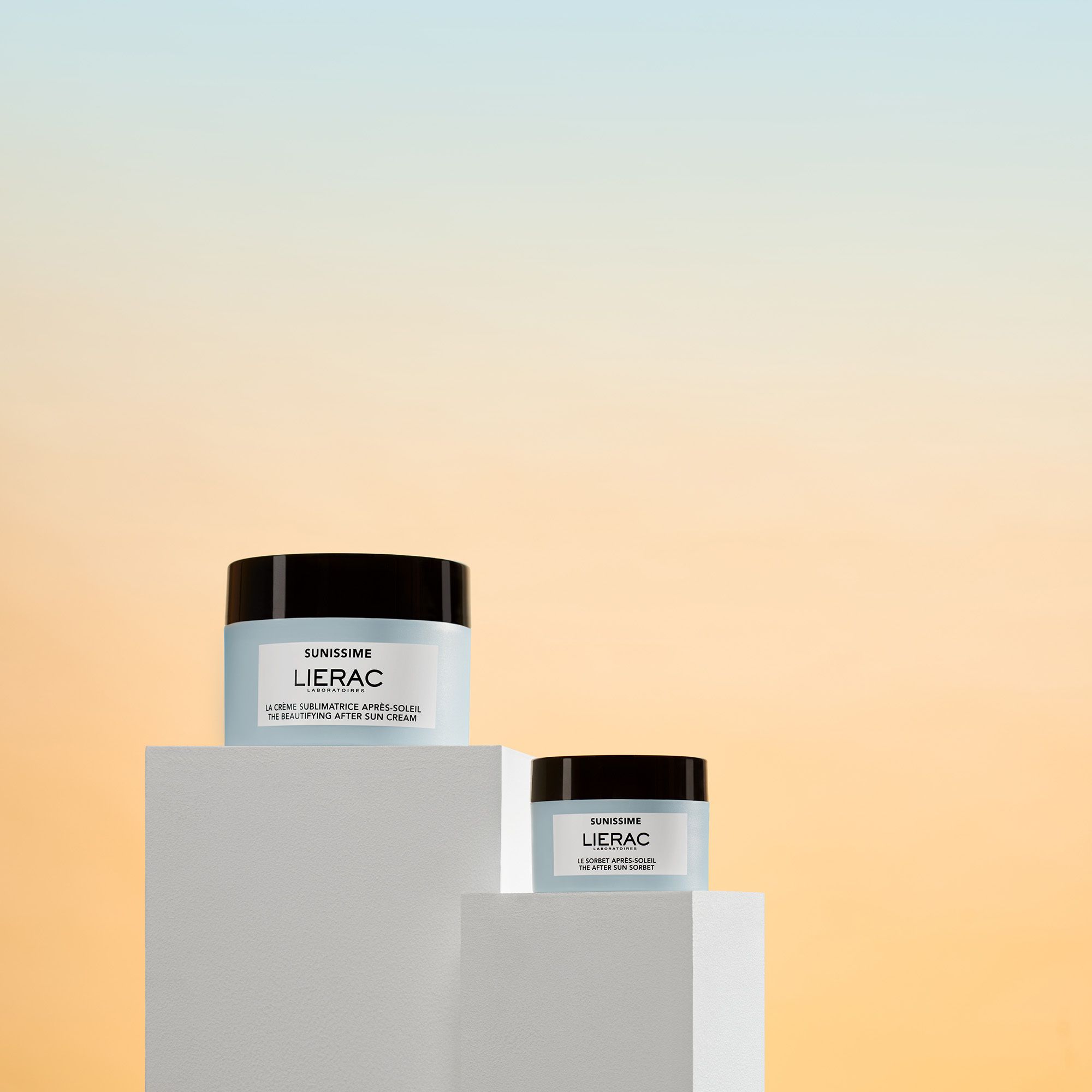 Twee lichtblauwe potten met zwarte deksel. Opschrift: Sunissime, Lierac. Tekst: La crème sublimatrice après-soleil.
