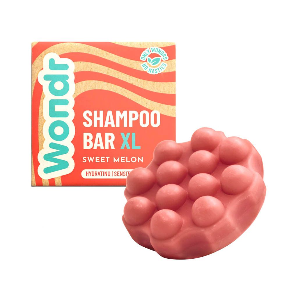 Roze shampoo bar met nopjes naast de verpakking. Verpakking: Wondr Shampoo Bar XL, Sweet Melon. Logo: Only Wondrs, No Nasties.