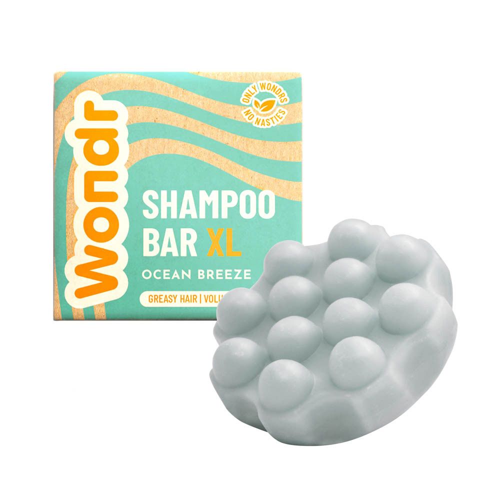 Kartonnen verpakking en shampoo bar. Bar is lichtgrijs en heeft een onregelmatige vorm met nopjes.
