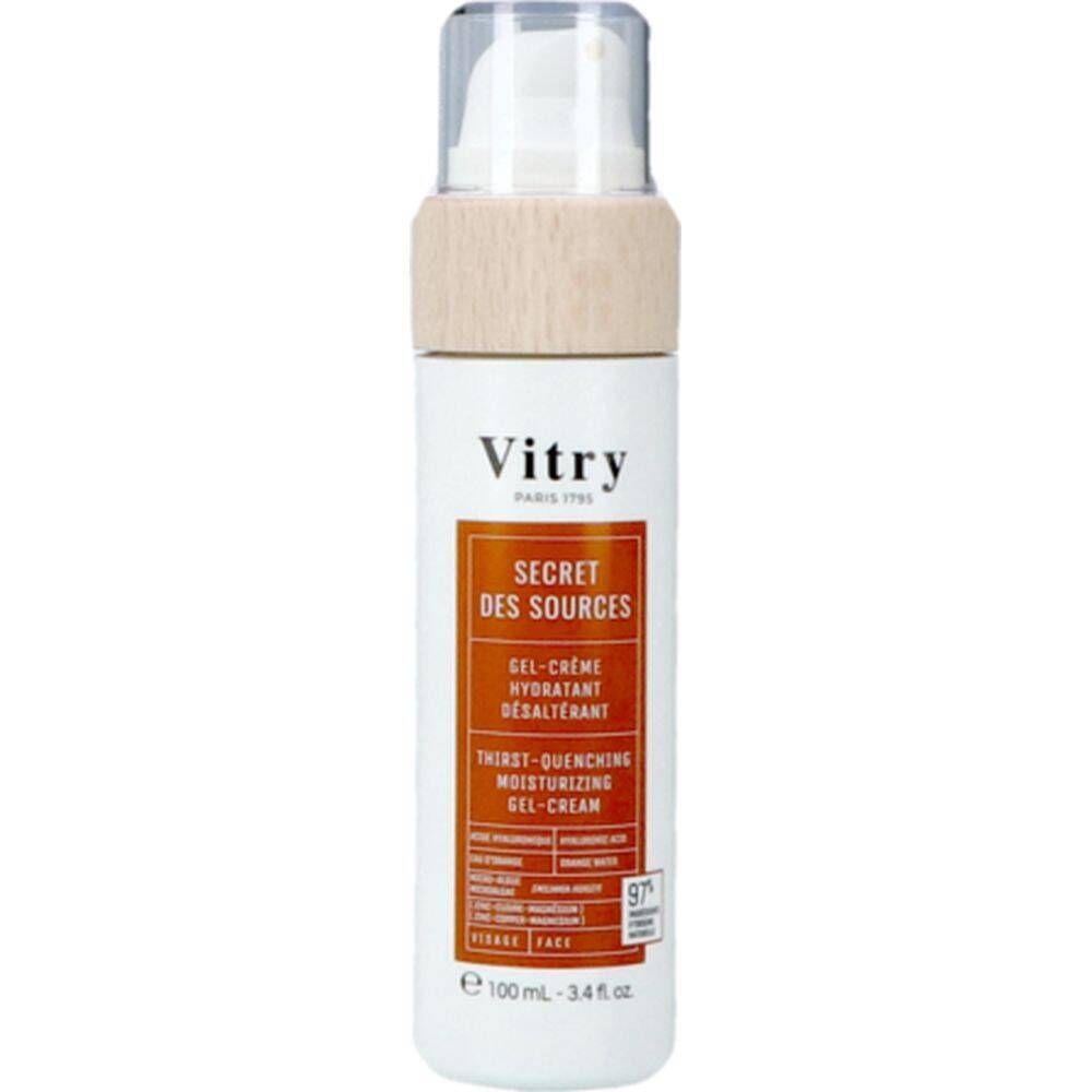 Flacon blanc avec pompe et bouchon aspect bois. Étiquette orange avec texte. "Vitry" et "Secret des Sources" visibles.