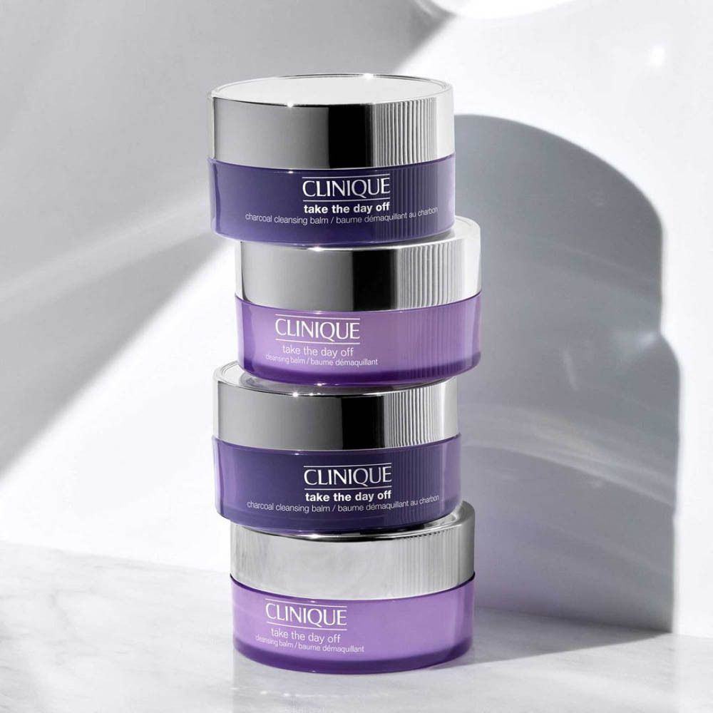 Vier potten CLINIQUE Take the Day Off, gestapeld. Paarse potten met zilveren deksels.