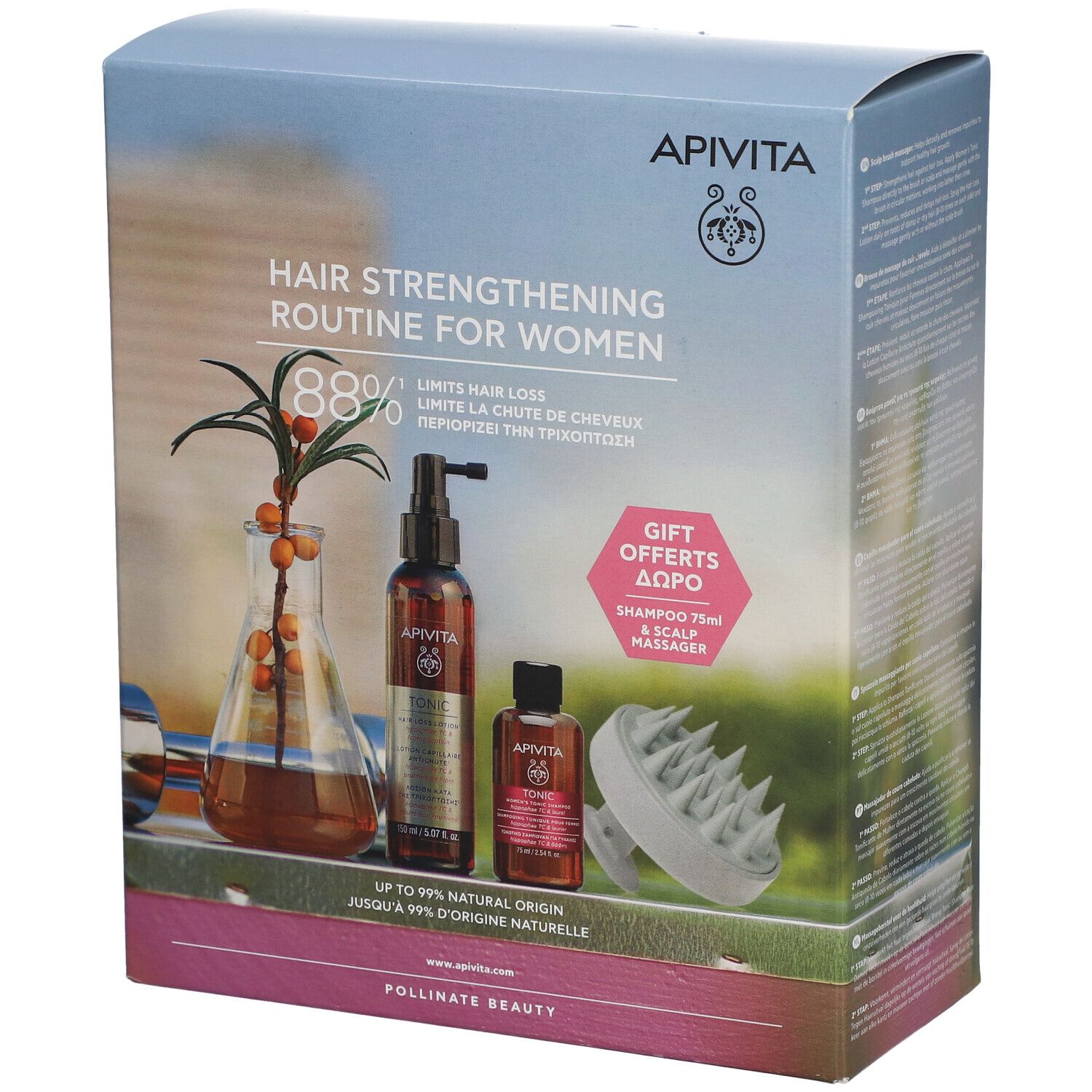 Verpakking met haarverzorgingsproducten. Bevat flessen, een massageborstel en tekst. Merk: Apivita.