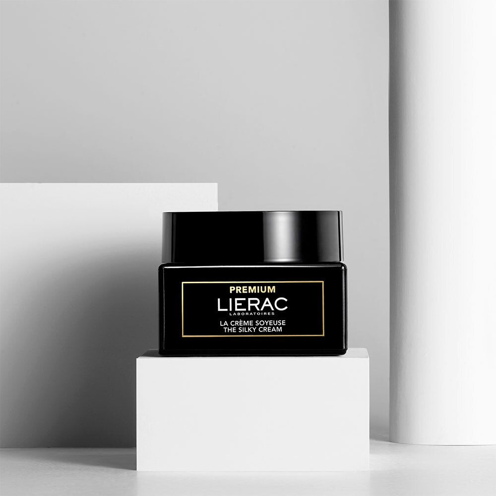Zwarte pot op witte sokkel. Gouden belettering: LIERAC PREMIUM. Tekst: LA CRÈME SOYEUSE THE SILKY CREAM.