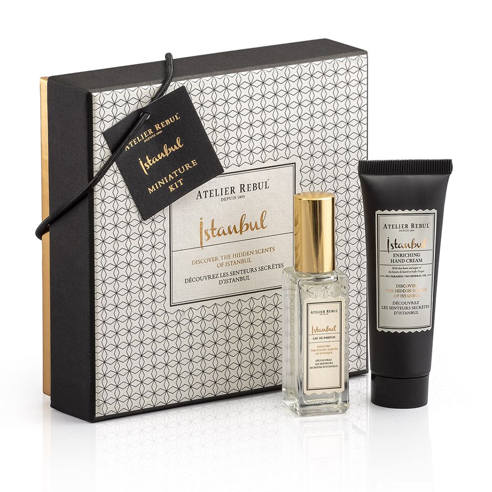 Geschenkset met flesje, handcrème en verpakking. Flesje met gouden dop. Zwarte tube met witte tekst.