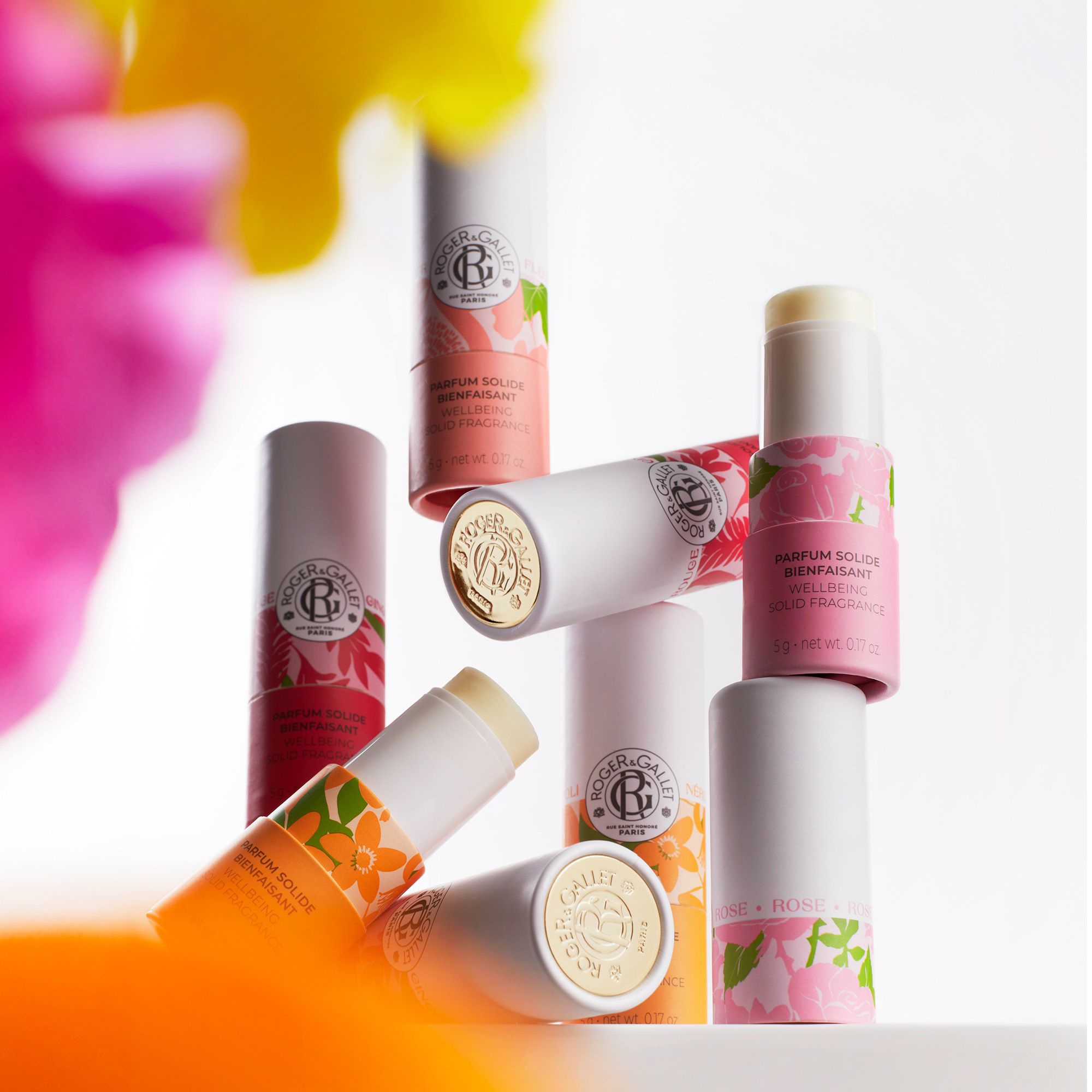 Meerdere cilindrische verpakkingen. Opschrift: Roger & Gallet, Parfum Solide. Verschillende kleuren en bloemen.