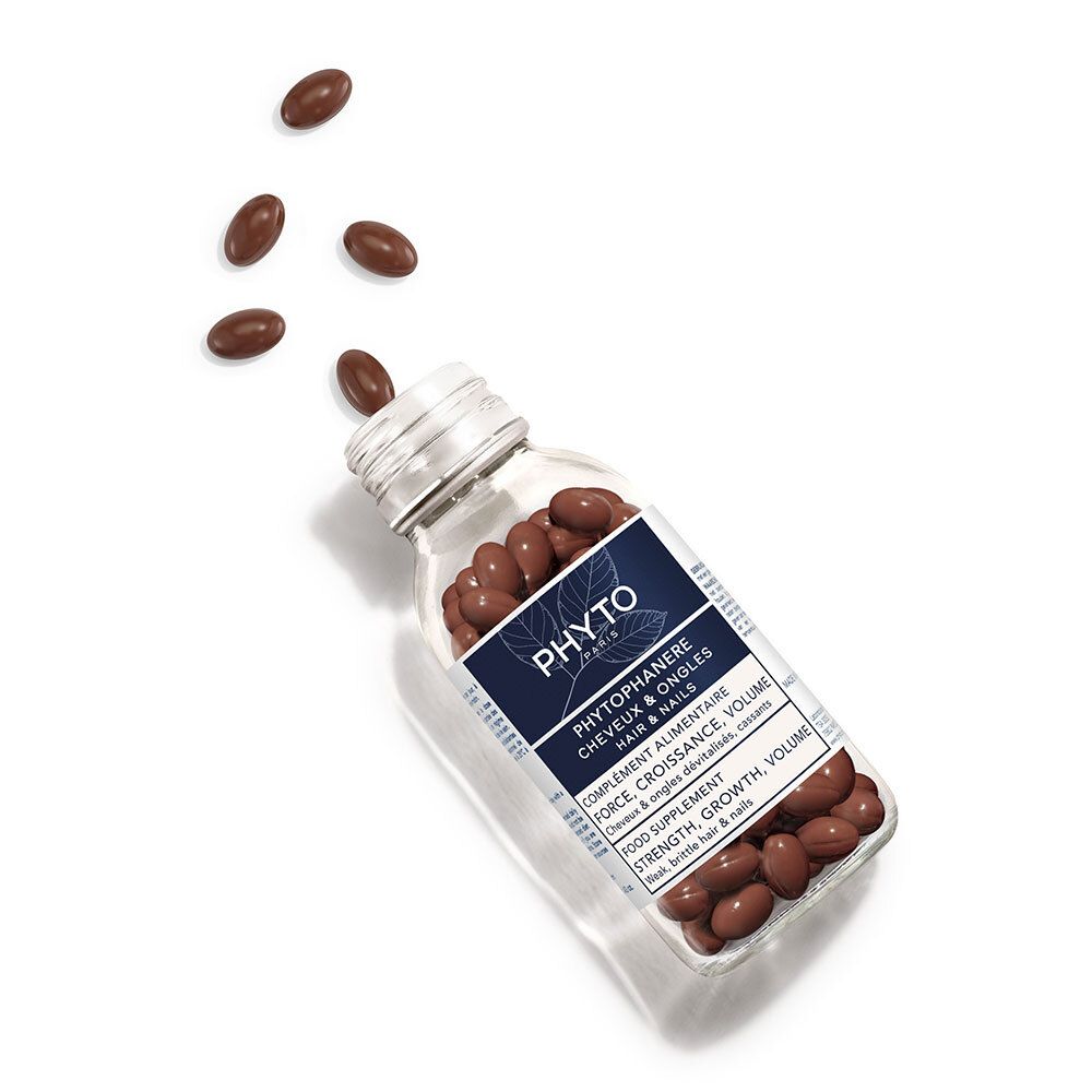 Glazen fles met bruine capsules. Enkele capsules vallen eruit. Opschrift: Phyto Phytophanère, haar & nagels.