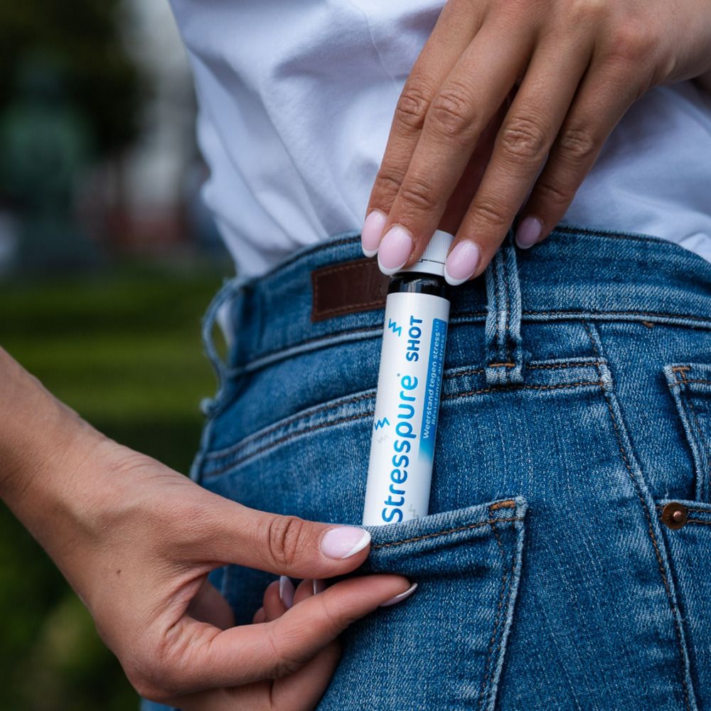 Une bouteille de shot. Inscription: Stresspure SHOT. Weerstand tegen stress. Résistance au stress. 14 x 25ml shots.
