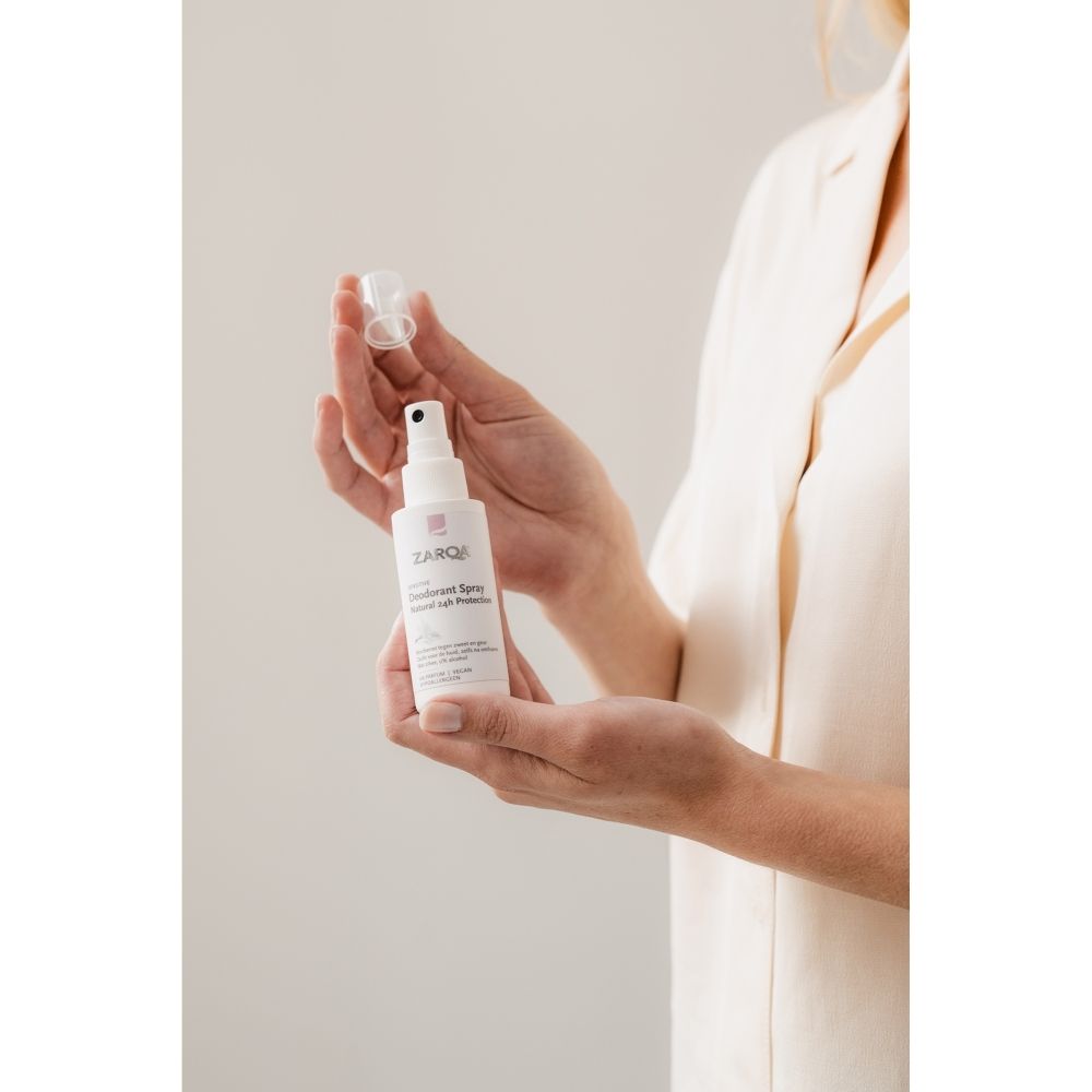 Witte spuitfles met transparante dop, gelabeld met 'ZARQE' en 'Sunscreen Spray'.
