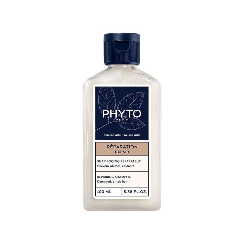 Flacon de shampooing. Shampooing blanc, bouchon bleu. Étiquette avec logo et texte: Réparation, Shampooing Réparateur, 100 ml.