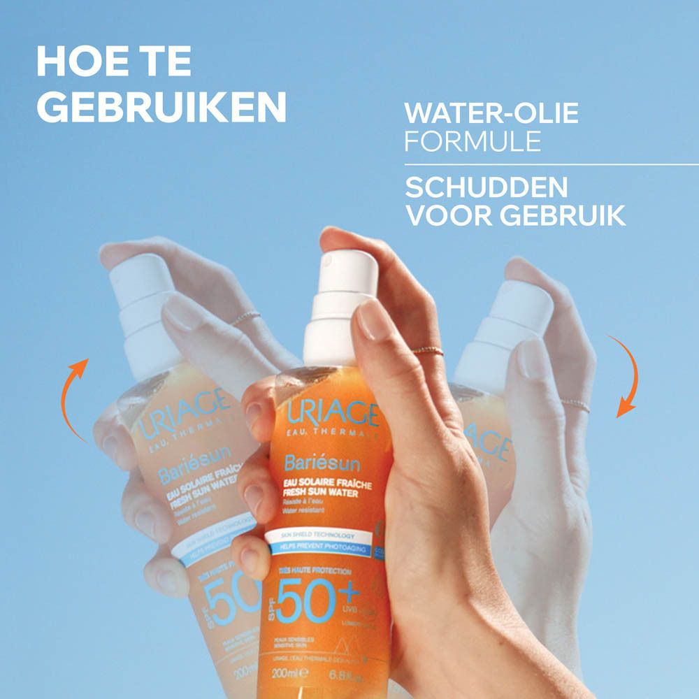 Handen schudden een Uriage Bariésun Eau Solaire Fraîche SPF50+ fles. Tekst: Water-olie formule. Schudden voor gebruik.