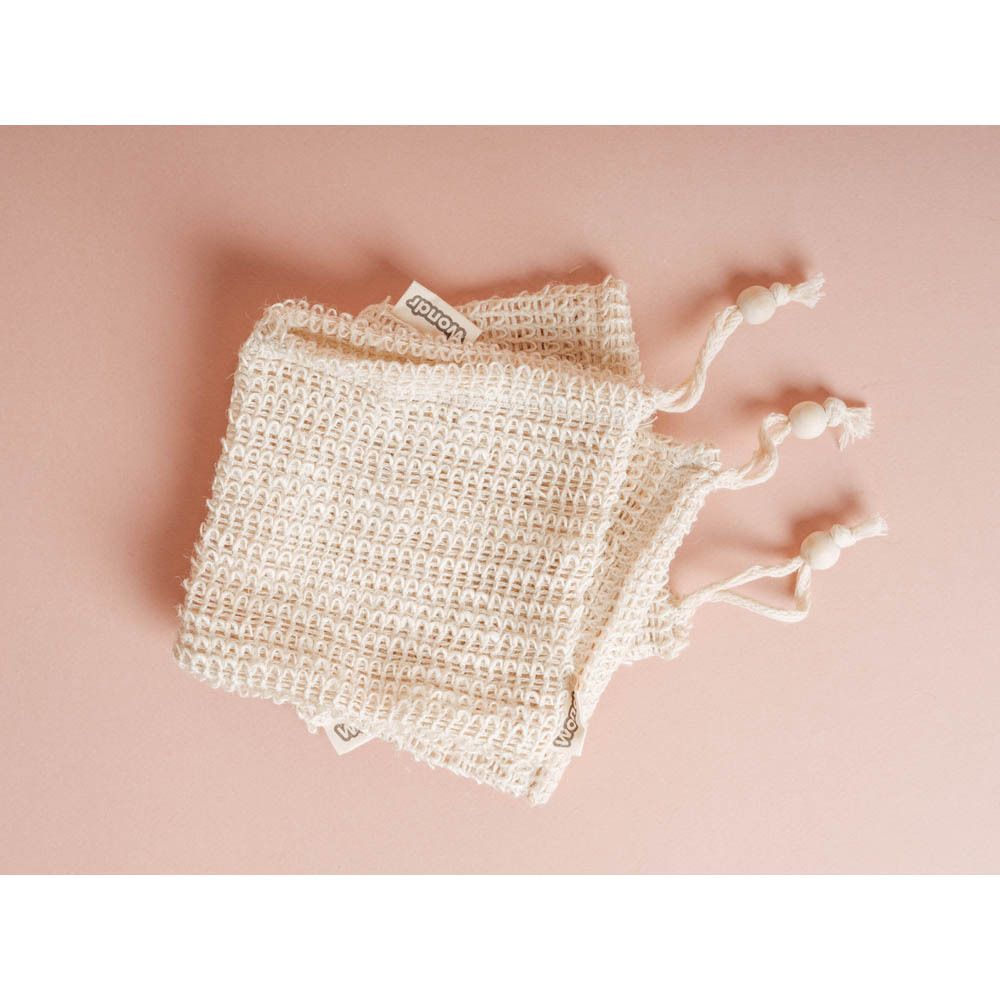 Drie beige waszakjes van bamboekatoen, trekkoord, houten kralen. Groen label 'wondr'.