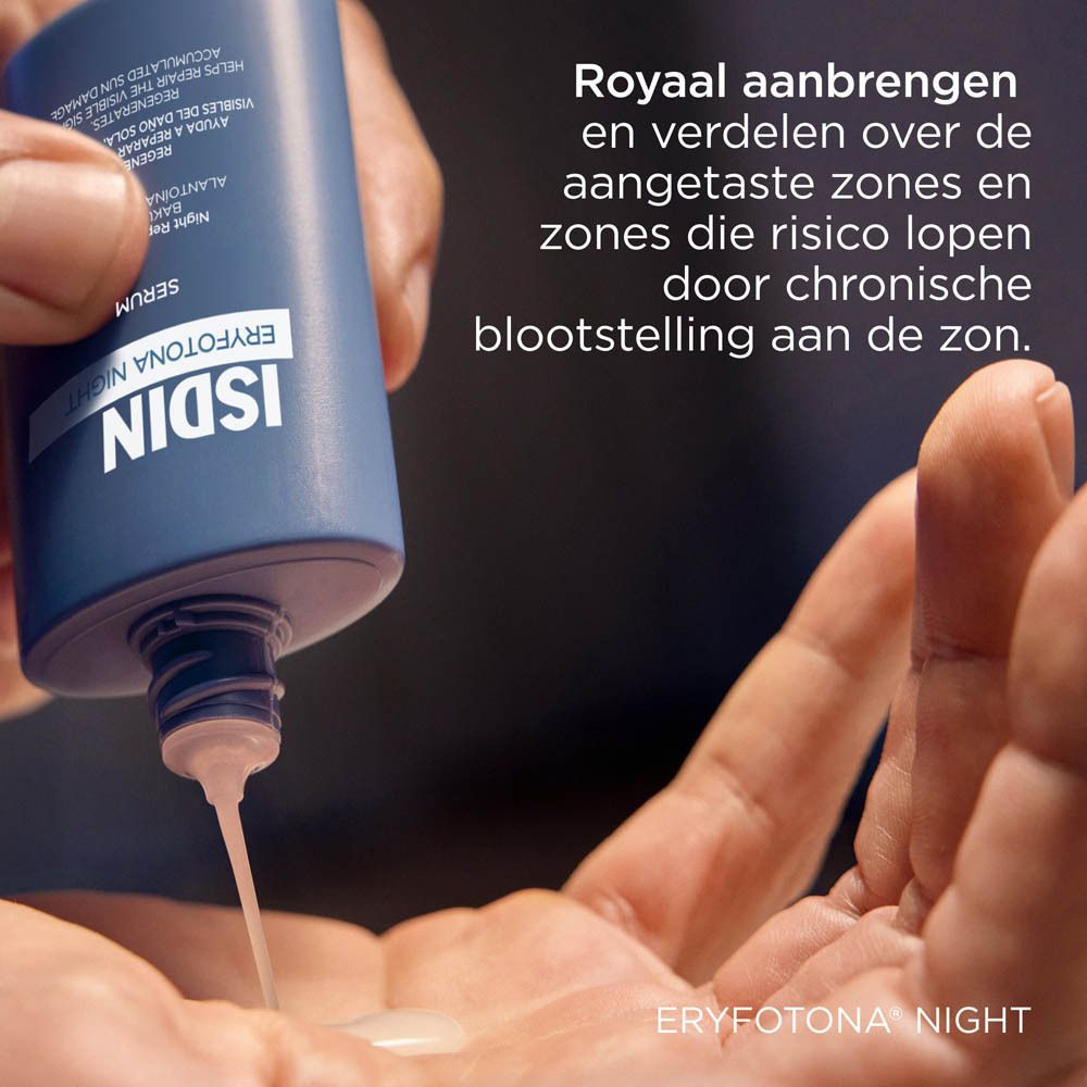 Hand giet ISDIN Eryfotona Night Serum op de handpalm. Blauwe fles.