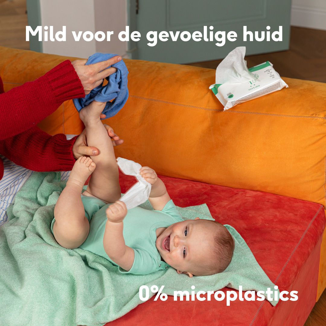 Baby ligt op een deken, een hand reinigt de voeten. Tekst: Mild voor de gevoelige huid. 0% microplastics.