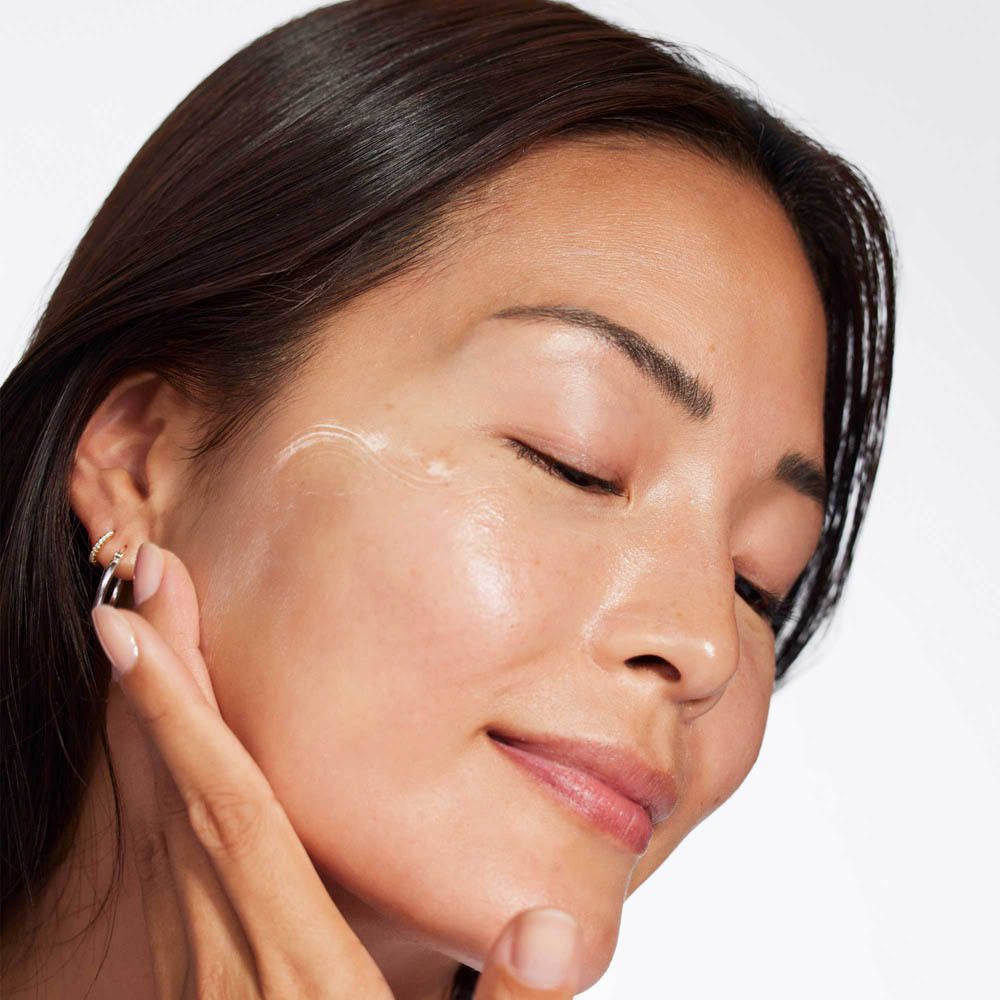 Vrouw die Clinique Smart Clinical Repair serum aanbrengt.