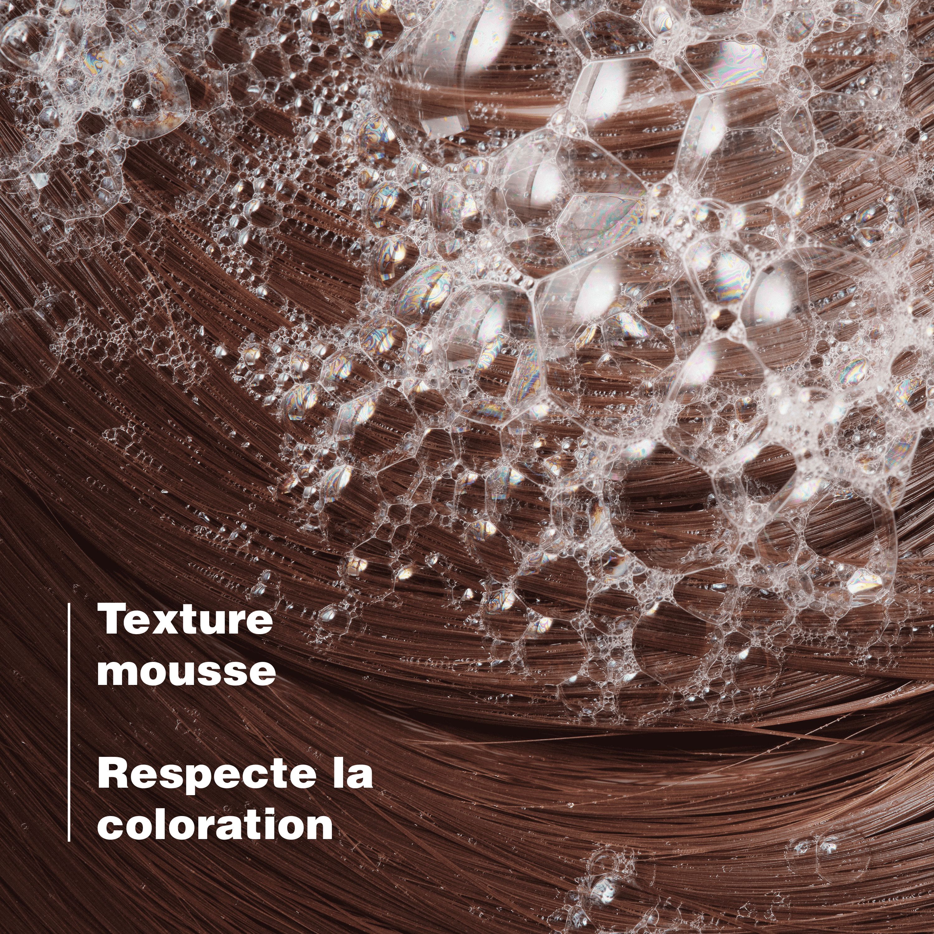 Gros plan sur cheveux bruns avec mousse. Texte: Texture mousse, Respecte la coloration.