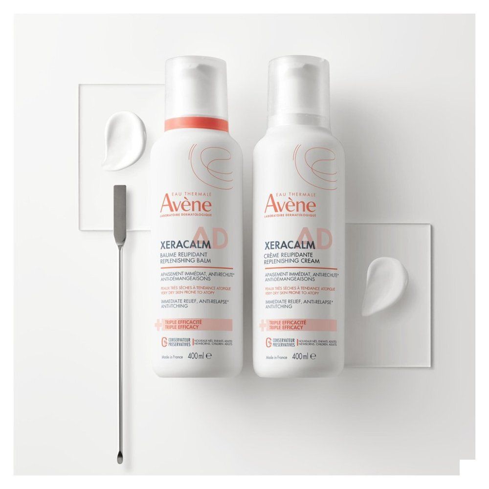 Deux produits Avène Xeracalm AD. Crème et baume. Fond blanc avec accessoires.