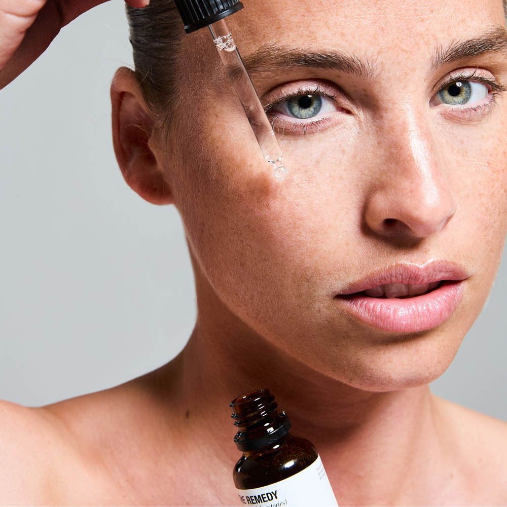 Achterkant van een bruine glazen fles met druppeldop, etiket met ingrediënten en "5 Types of Hyaluronic Acid".