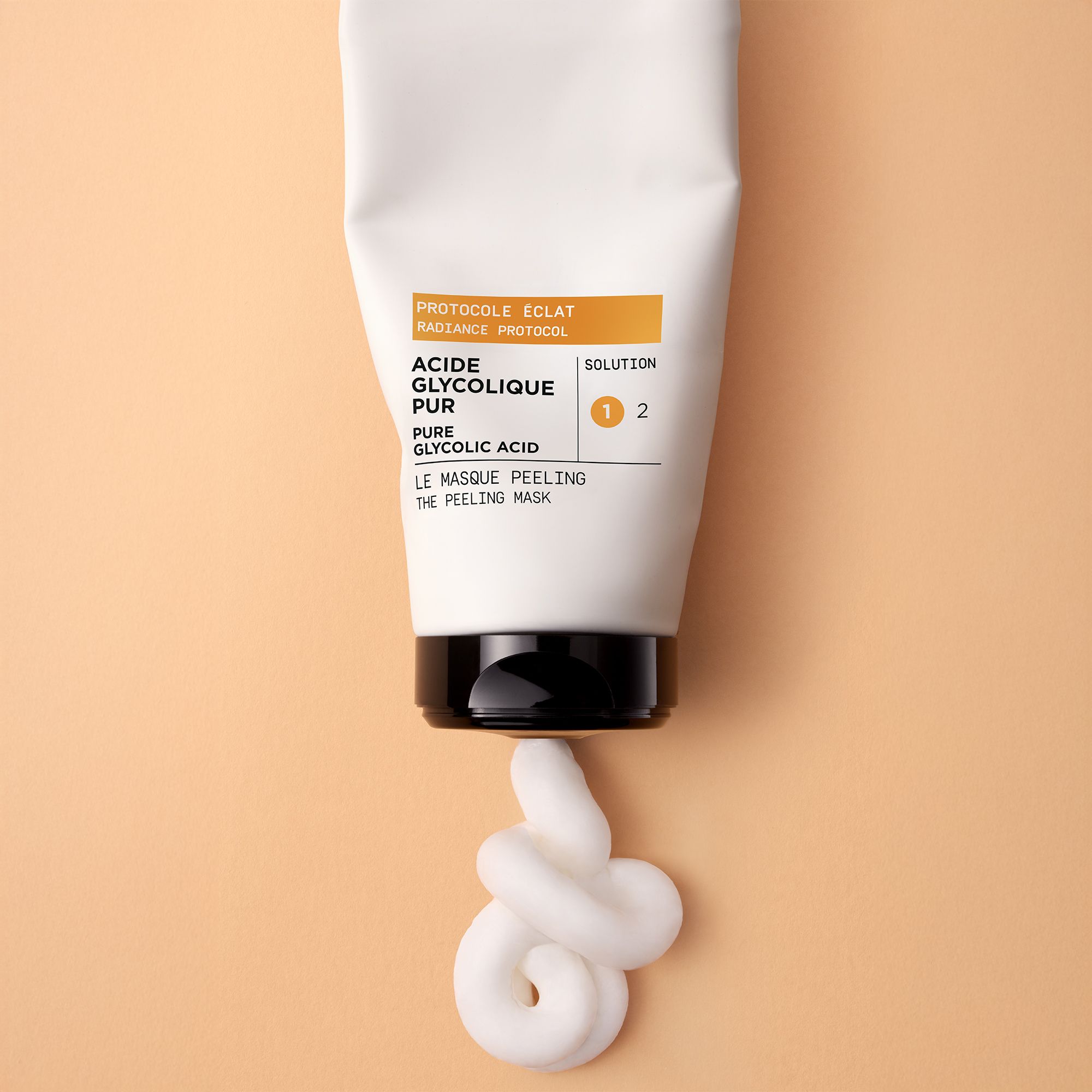 Witte tube, product wordt eruit geperst. Opschrift: LIERAC, PROTOCOLE ÉCLAT, ACIDE GLYCOLIQUE PUR.