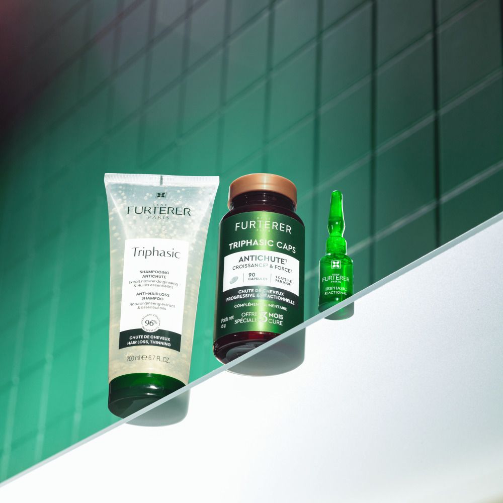 Drie producten: shampoo, capsules en ampul. Opschrift: René Furterer Triphasic.
